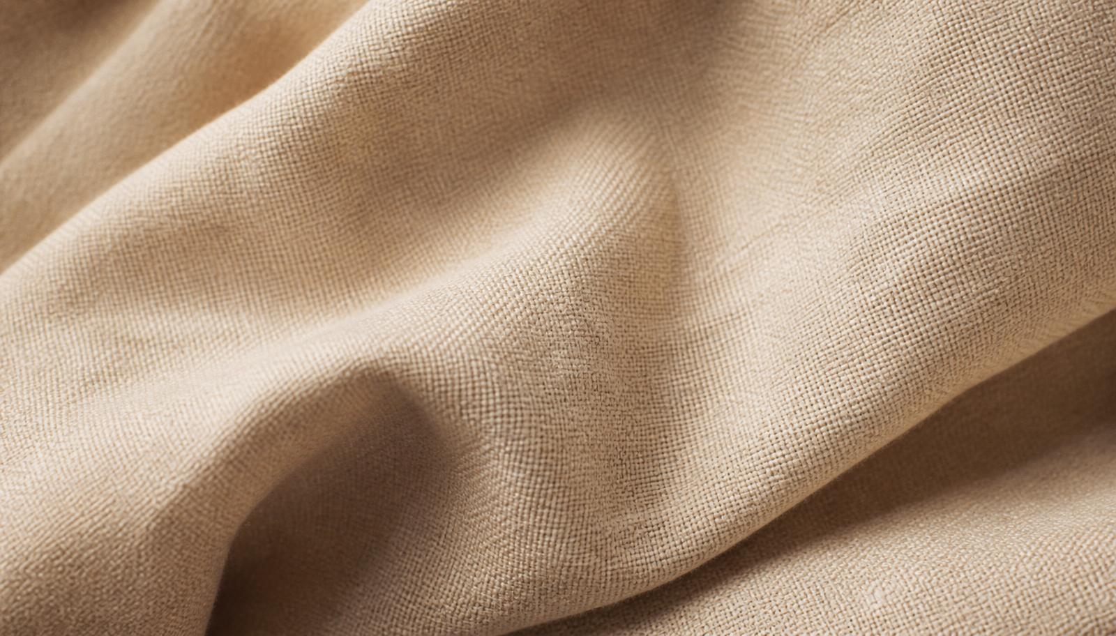 Close detail of softly folded oat-colored linen